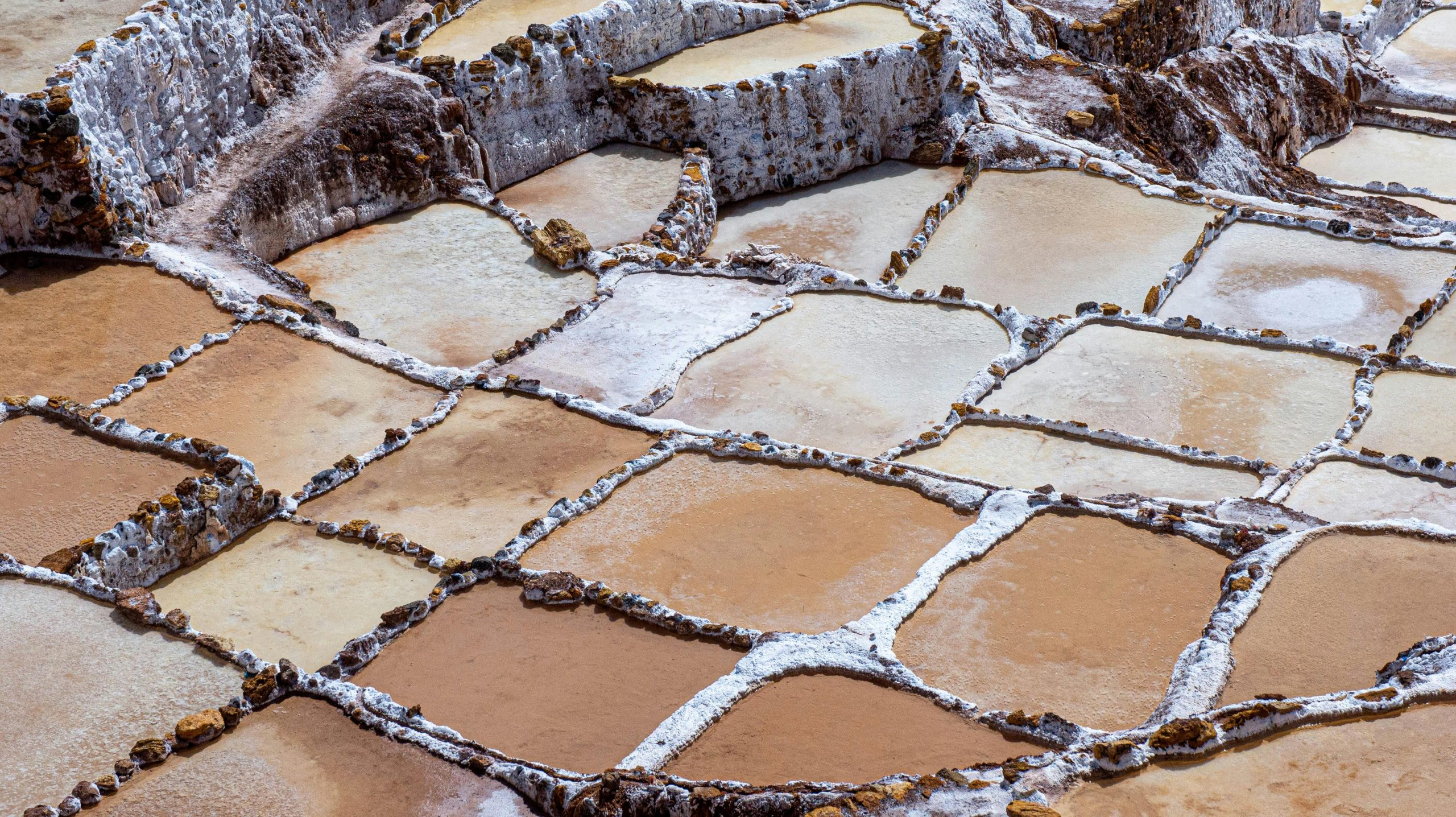 A stunning aerial view of salt pans with distinct sections in a rural landscape.